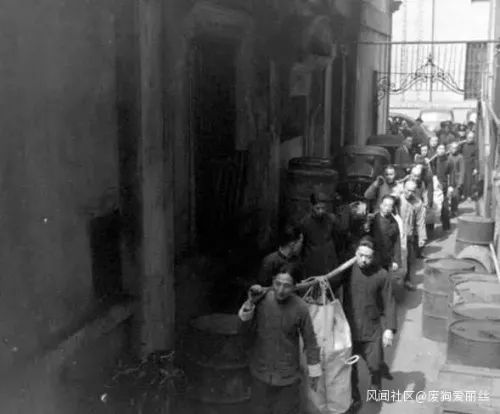  图为1948年上海，工人用麻袋扛着法币前去发薪。