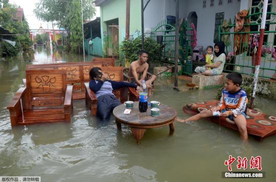 資料圖片:近日,暴雨襲擊印尼蘇拉威西島南部,數十個小區被水淹沒。圖爲當地時間1月25日,印尼南蘇拉威西省望加錫的一居民區內,居民在清點家中財產。