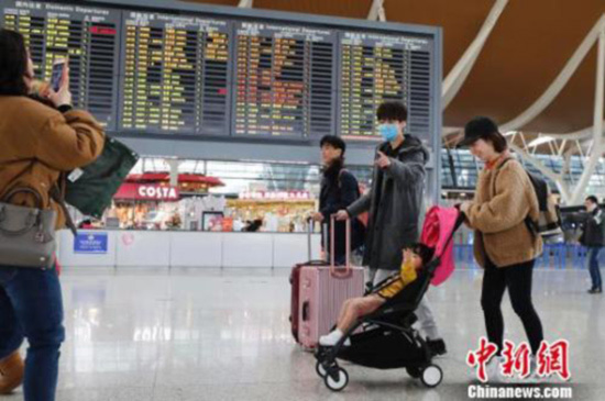 资料图:旅客带着孩子前往办票柜台办理登机手续。殷立勤 摄