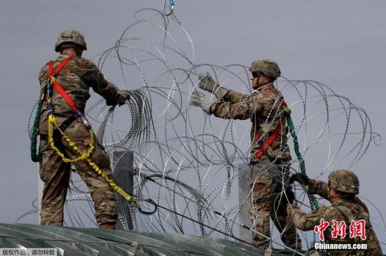当地时间2018年11月2日，美国得州Hidalgo，中美洲移民大军压境美国，美国士兵在美墨边境安装铁丝网严防移民入境。