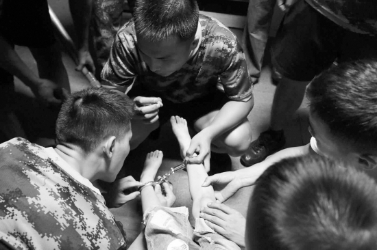 8月29日，永州零陵区，消防官兵正准备破拆铐住男孩双脚的手铐。图/受访者提供