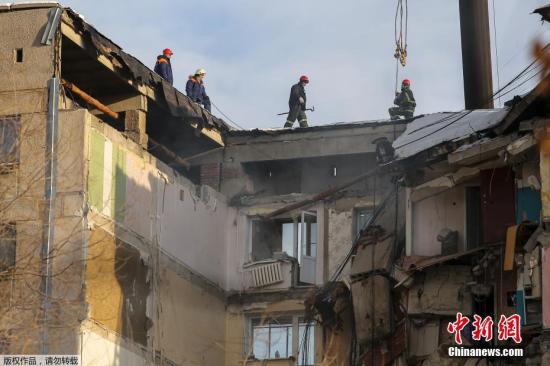 当地时间1月1日，救援人员在俄罗斯马格尼托哥尔斯克市因天然气爆炸部分倒塌的公寓大楼上进行救援工作。据外媒报道，这起事故发生于当地时间12月31日早上约6时。由于当天是俄罗斯的公定假日，因此事发当时多数居民仍在熟睡中。