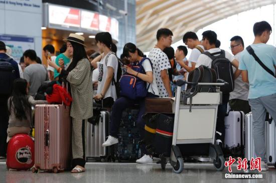 資料圖爲旅客排隊等待辦理登機手續。 殷立勤 攝