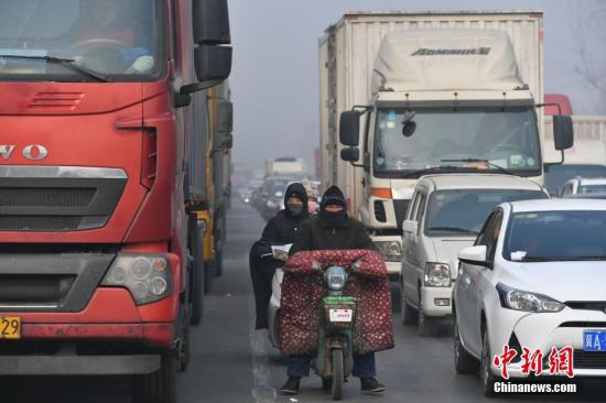 資料圖:摩托車手在車流中穿行。翟羽佳 攝