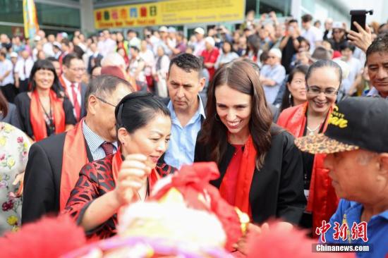 2月2日，作为新西兰奥克兰市一年一度最具人气的中国新年庆祝活动——2019“欢乐春节”新春花市同乐日活动在奥克兰ASB会展中心开幕，新西兰总理杰辛达·阿德恩为花市舞狮团雄狮挂上节日绣球。中新社发 张健勇 摄