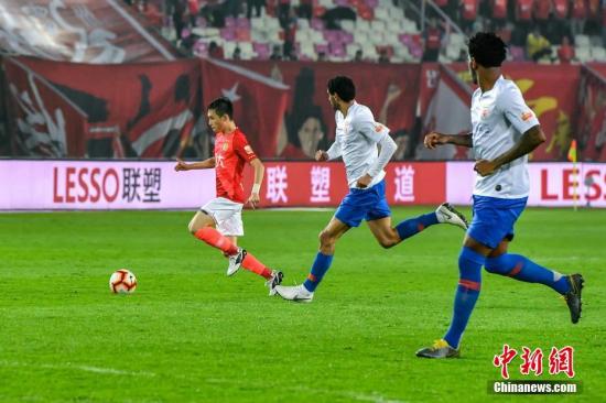 资料图：如今已转投广州恒大俱乐部的张修维（左）在比赛中突破对手防线。 中新社记者 陈骥旻 摄