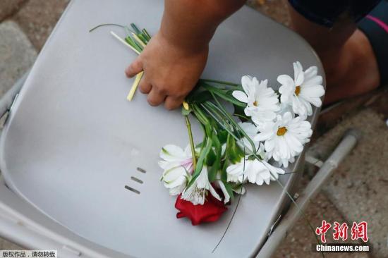 9月1日,在美国得克萨斯州敖德萨市,一名女子手握悼念遇难者的花束。