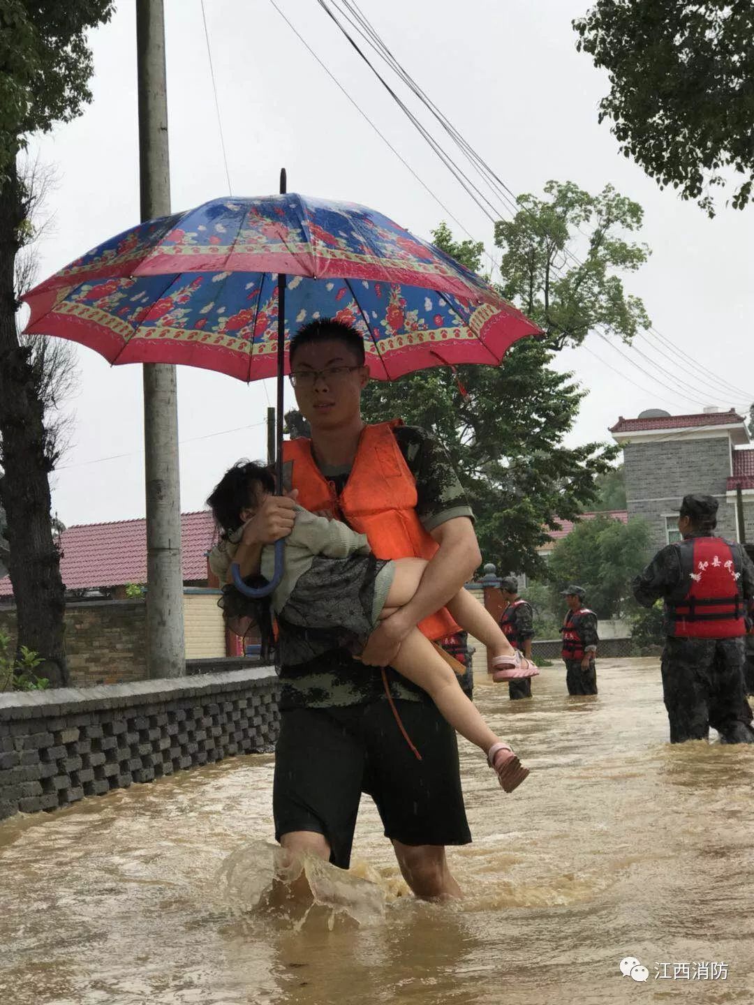 江西吉安多地洪灾 婴儿为消防战士撑伞(图)