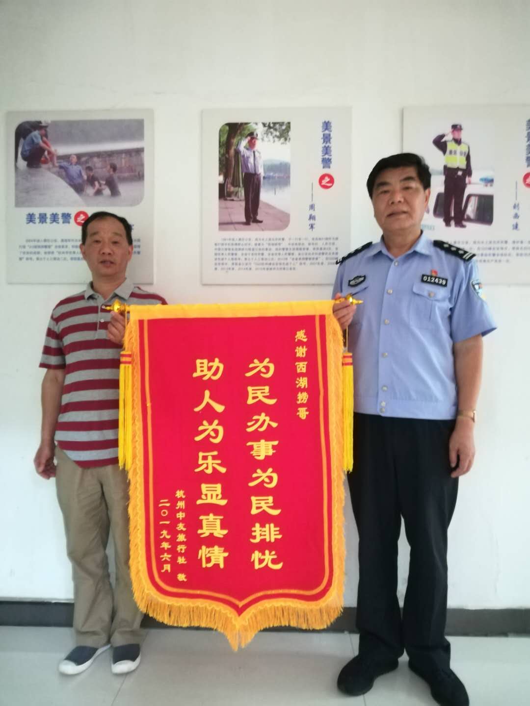 周翔军（右）帮助游客打捞手机，游客送来锦旗表示感谢。  受访者供图