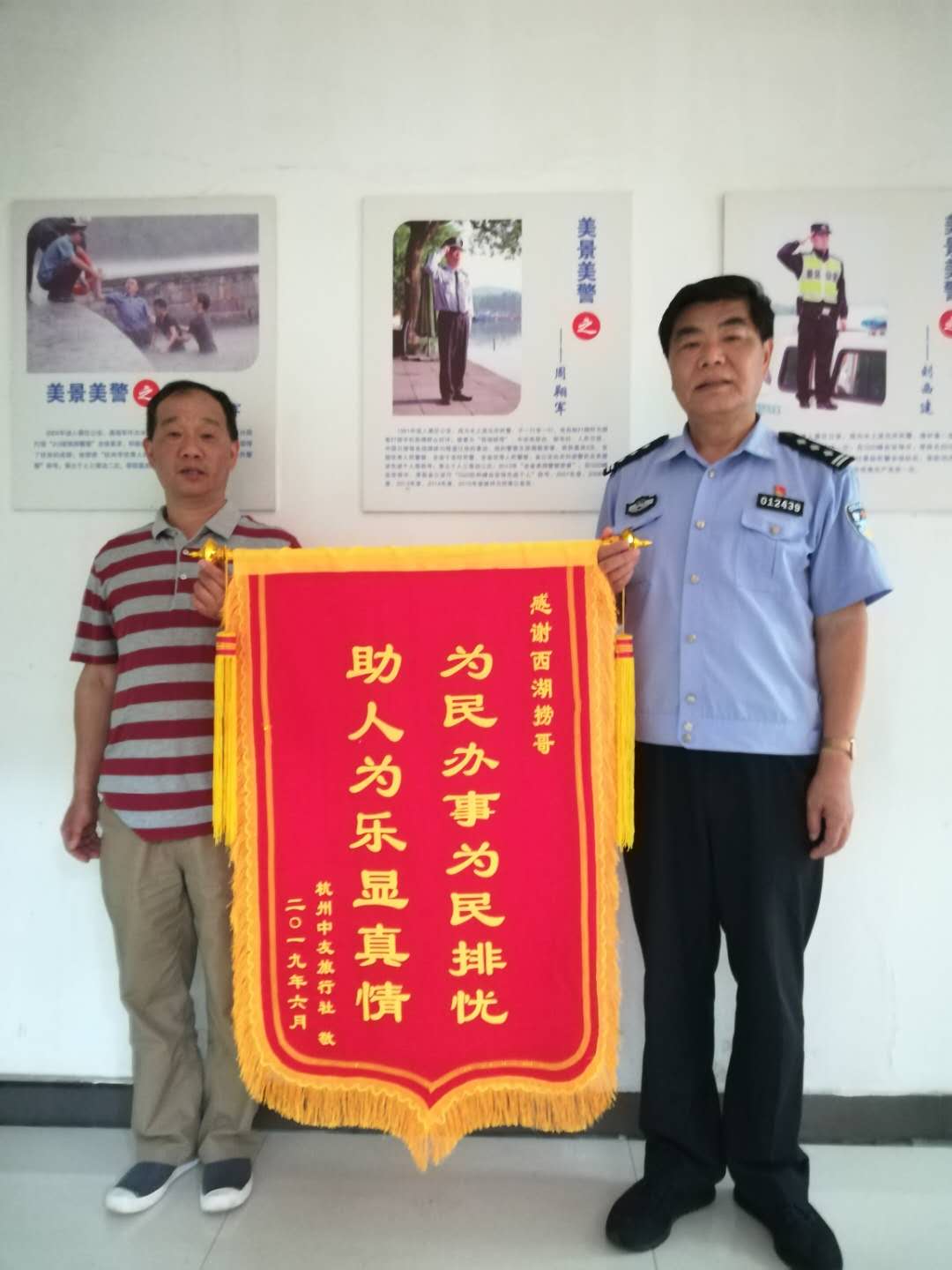 周翔军(右)帮助游客打捞手机,游客送来锦旗表示感谢。 受访者供图