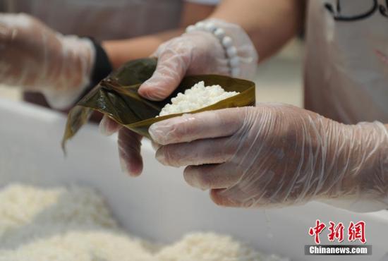 资料图:人们在包粽子。(<a target='_blank' href='http://www.chinanews.com/'>中新社</a>记者 刘栋 摄)