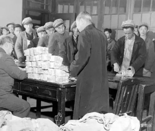 图为1948年上海，工人排队领薪水。