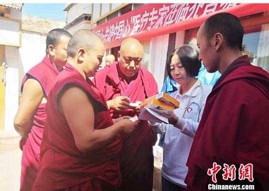 图为专家为僧人叮嘱服药注意事项。 南如卓玛 摄