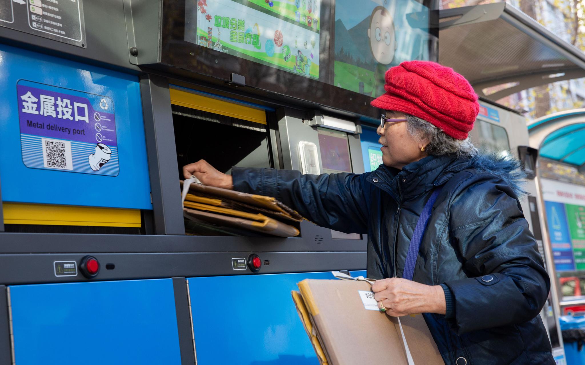 11月25日，崇外街道新怡家园居民把纸盒投入智能垃圾桶的可回收物投放口。新京报记者 李凯祥 摄