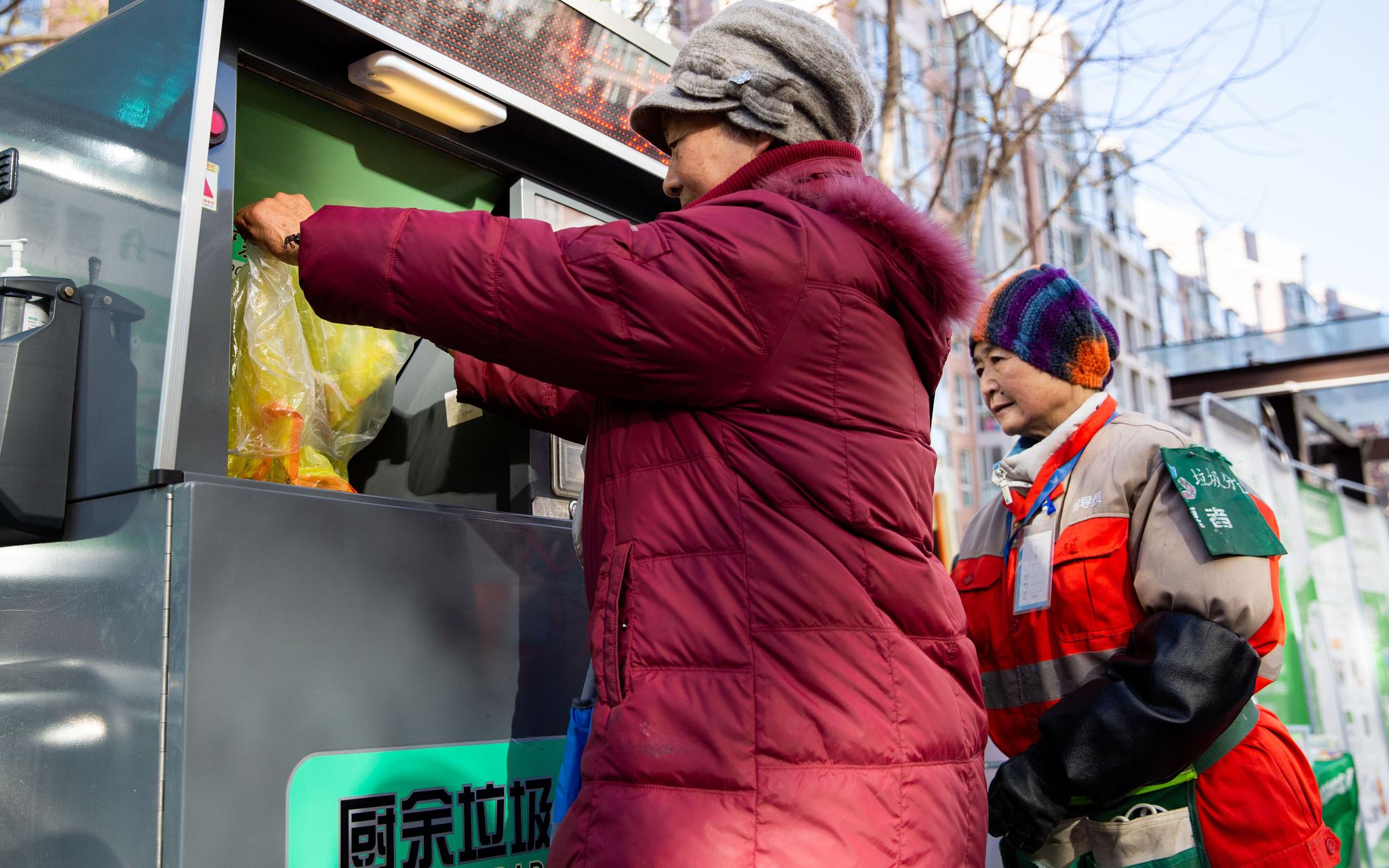 11月25日，指导员韩瑞香帮助居民孙奶奶操作智能垃圾桶。新京报记者 李凯祥 摄