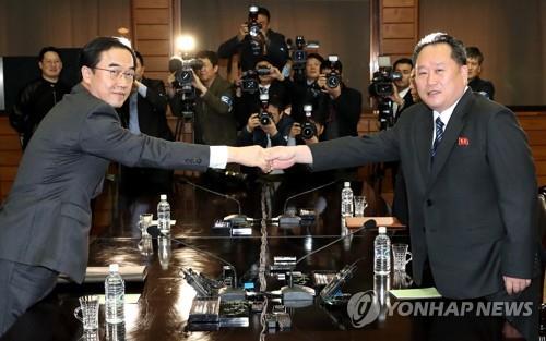 今年3月29日,韩国统一部长官赵明均(左)与朝鲜祖国和平统一委员会委员长李善权(右)在板门店举行的朝韩高级别会谈上握手致意。(图片来源:韩联社)