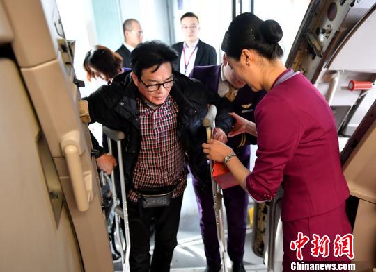 工作人员帮助特殊旅客乘机。 李佩珊 摄