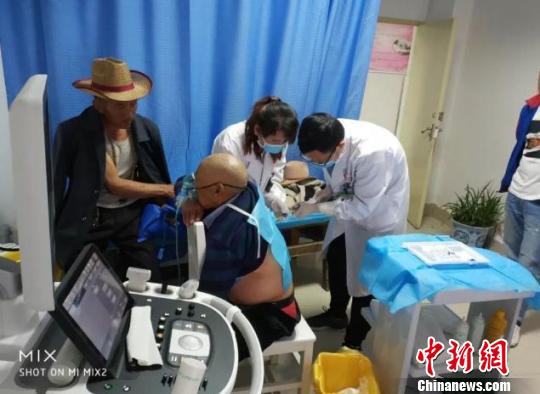 图为:王俊在松藩县人民医院为病人进行治疗 浙江临海市第一人民医院供图 摄