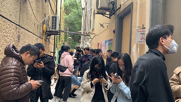 在咖啡店门口排队等营业的人群。
