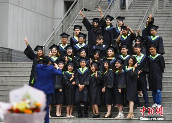 6月13日，新疆农业大学校即将毕业的大学生身着学士服在校园内拍摄毕业照。刘新 摄