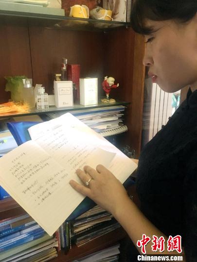 图为刘传健妻子邹函在家中翻阅丈夫的工作笔记。　刘贤　摄