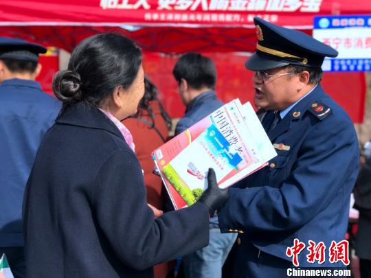 图为消费者向执法人员询问。 孙睿 摄