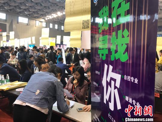 毕业生向用人单位投放简历。 杨静 摄