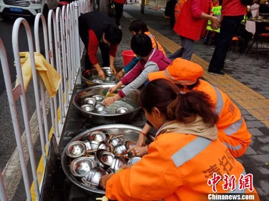 图为就餐者主动帮忙收拾桌椅、清洗碗筷。 史雪枫 摄