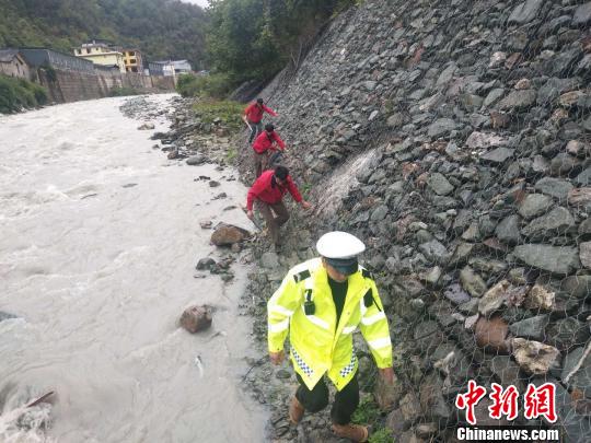 图为救援人员沿河道搜救。