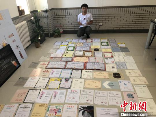 图为段鹏翔与他的126张证书。 陈峰 摄