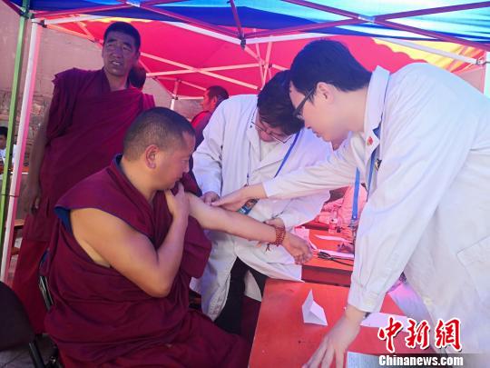 图为专家为僧人诊疗。 南如卓玛 摄