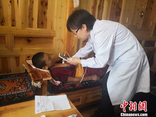 图为医疗专家在僧舍内为小僧徒筛查先天性心脏疾病。 南如卓玛 摄