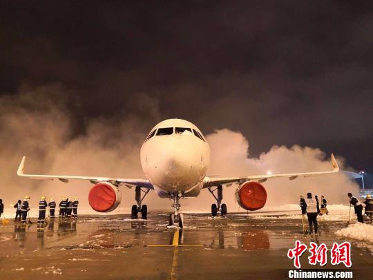 8日晚,大雪纷飞致南京禄口国际机场跑道关闭,机场内在紧张进行扫雪除冰工作。 赵阳 摄