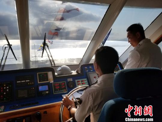 “蜈支洲三号”客船驾驶舱内,船长在一旁观察瞭望。 王晓斌 摄