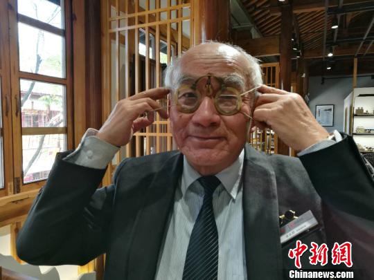 图为73岁的特级眼镜调校师章永祥展示古董眼镜戴法。 胡远航 摄