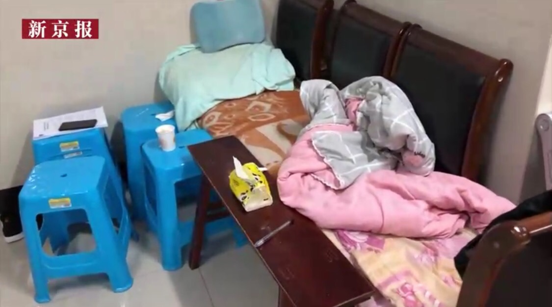 叶万焕用四张凳子拼成一个简易床,在殡仪馆住了半年。 新京报“我们视频”截图