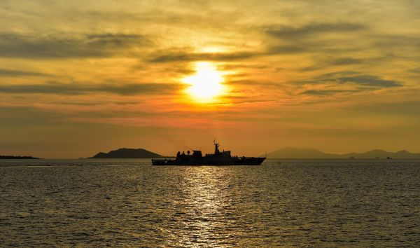资料图:驶离码头的海警3304舰航行在夕阳中。新华社记者 毛思倩 摄