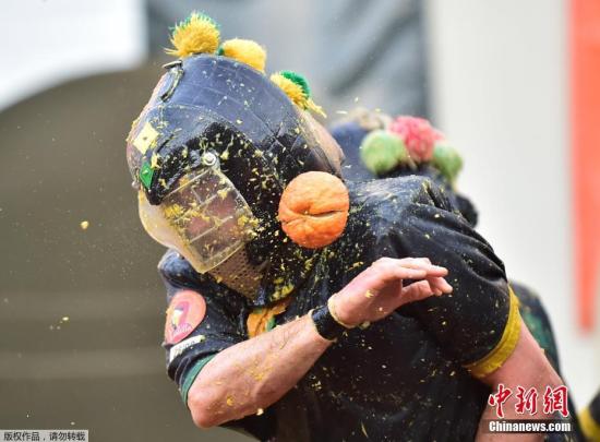 资料图：当地时间3月3日，意大利伊夫里亚举行一年一度的传统狂欢节，市民用橙子展开“大战”。