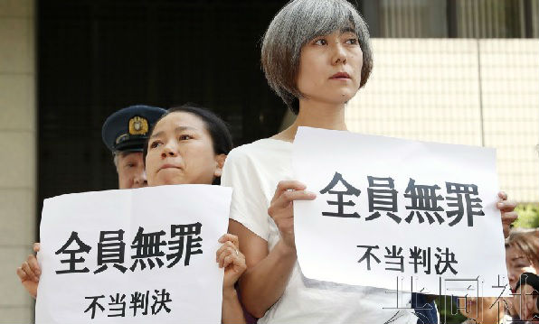 市民手举反对标语表达对判决结果的不满。(共同社)