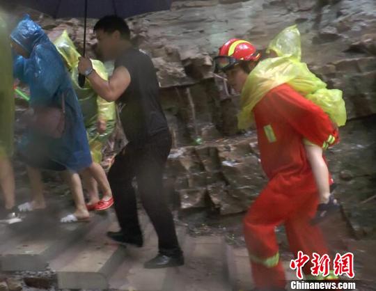 疏导中消防人员背着孩子前进 消防供图 摄 暴雨致26名游客被困景区 河北承德消防成功救援