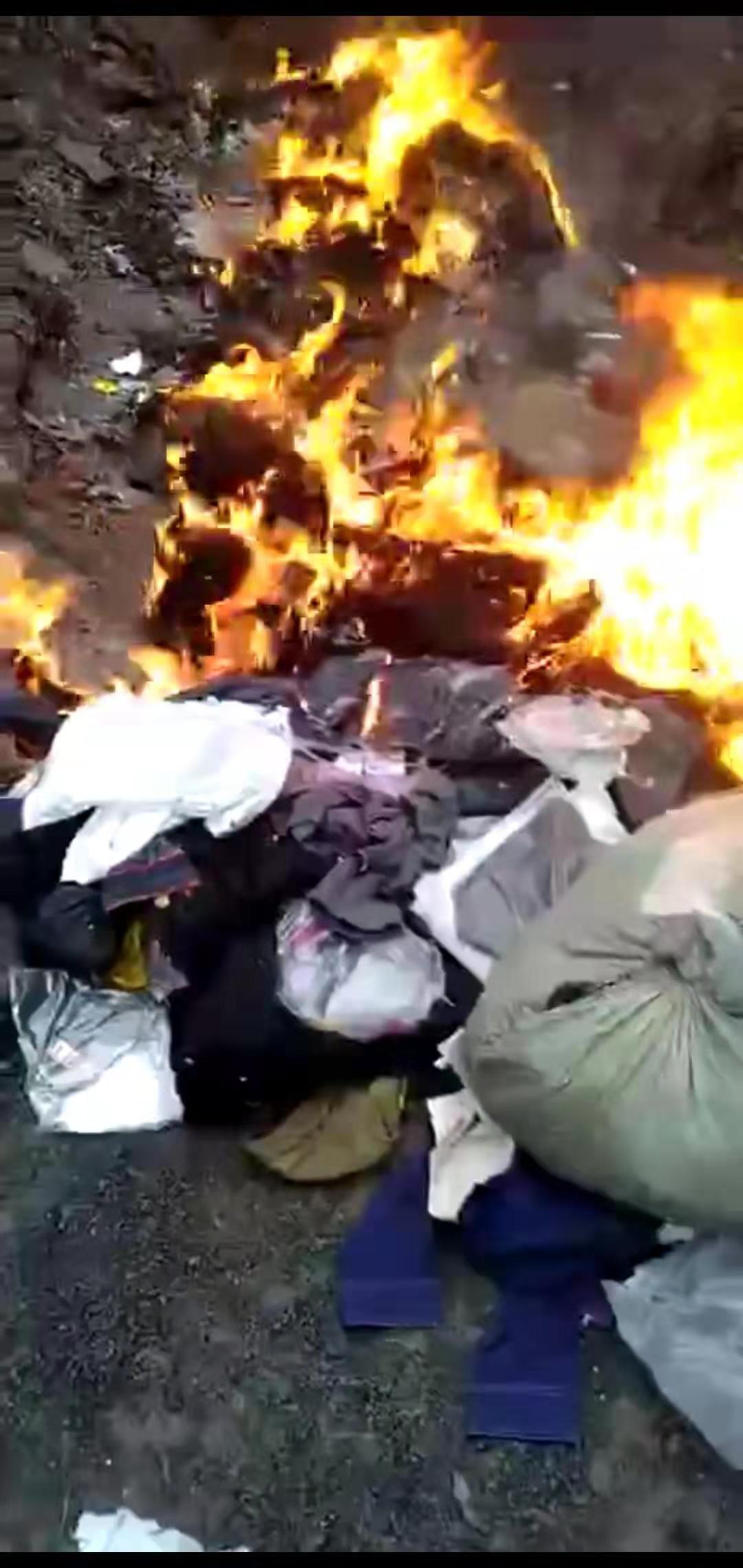 视频显示,大批袋装衣服正在被烧毁。视频截图