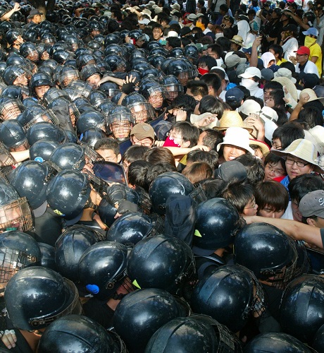 2006年8月14日，在韩国首都首尔，反美游行队伍与防暴警察发生冲突。当日，韩国民众举行了要求驻韩美军撤兵、呼吁和平的抗议示威活动。 新华社记者李拯宇摄