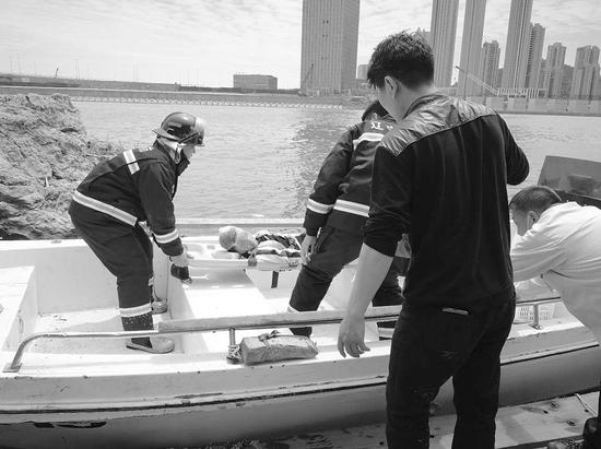 消防人员将男孩用船送到岸边。