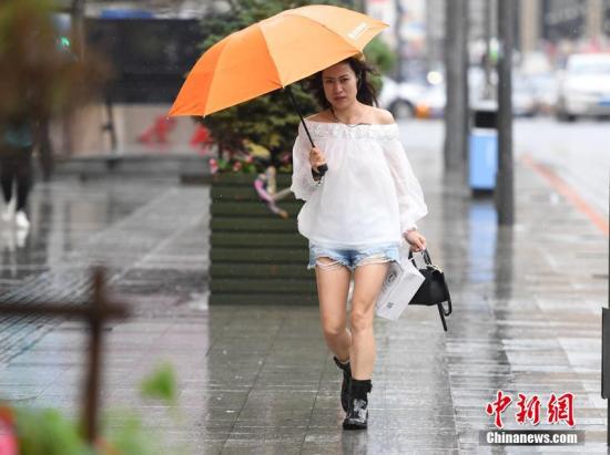 資料圖:颱風中市民打傘出行。張瑤 攝