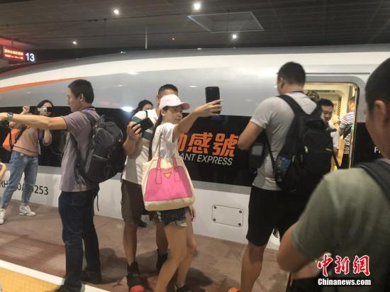 9月23日,广深港高铁香港段正式开通运营。民众在车前自拍。 中新社发 张茜茜 摄