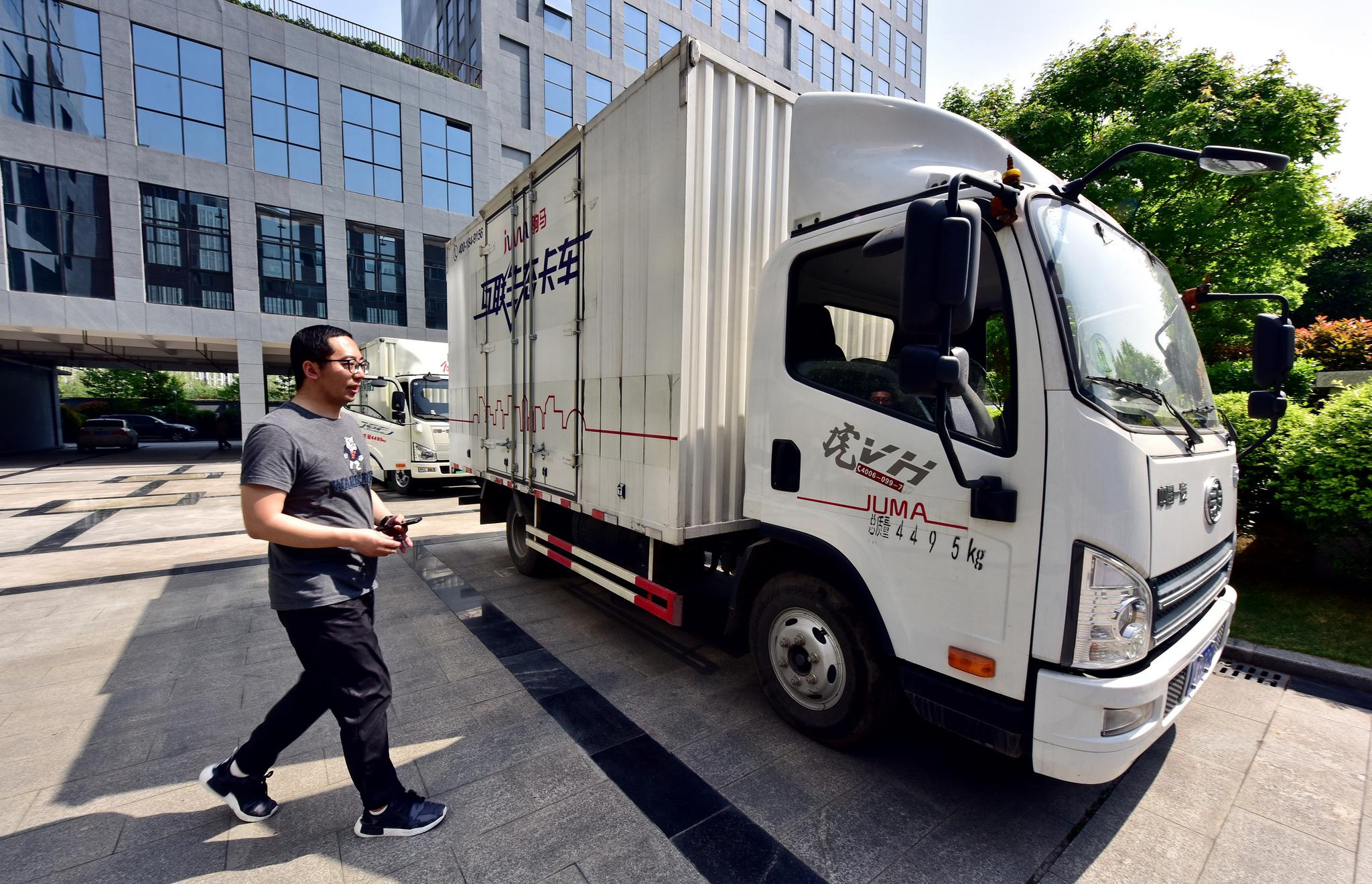 4月3日,四川成都,驹马物流总部楼下停放的货运车辆。摄影/章轲