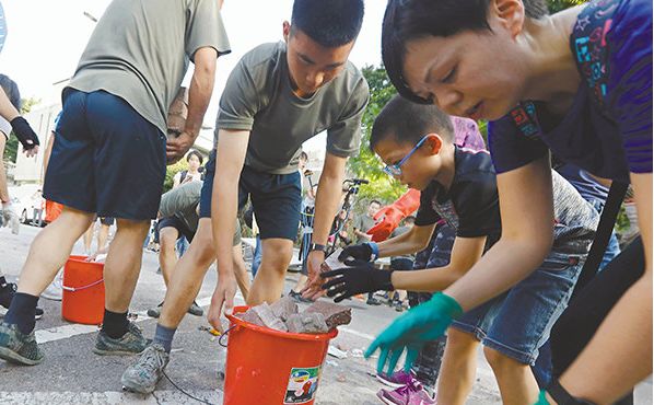 ▲驻港部队协助市民清理军营附近的路障,小朋友也“出手相助”。(《香港文汇报》)