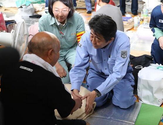 安倍首次视察日本暴雨灾区 双膝跪地慰问灾民(图)