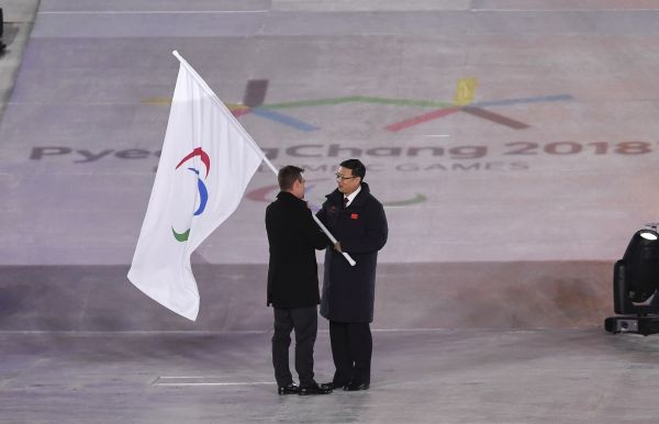 北京市市长陈吉宁(右)从国际残奥委会主席帕森斯手中接过国际残奥委会会旗。新华社记者夏一方摄
