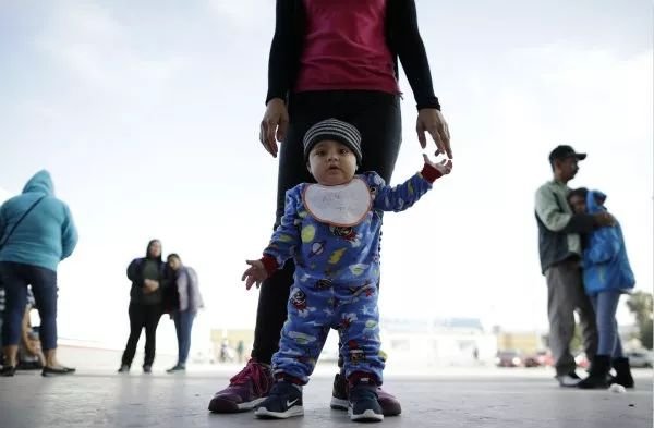 6月13日，在美墨边境墨西哥一侧的蒂华纳，一名儿童和他的母亲等待进入美国。新华社/美联
